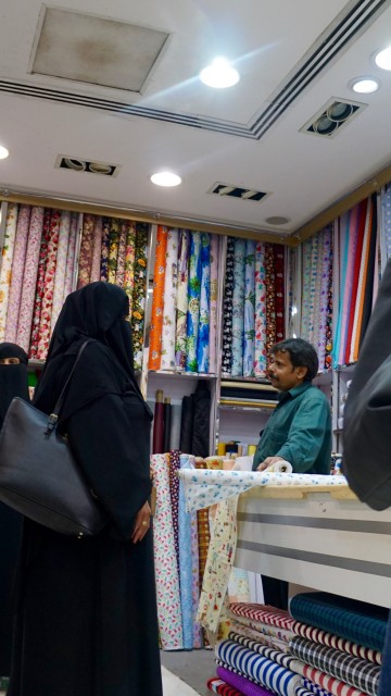 Arab woman in full abaya with Indian fabric proprietor.