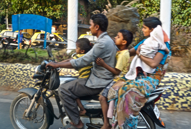 Family on the move…No helmets.