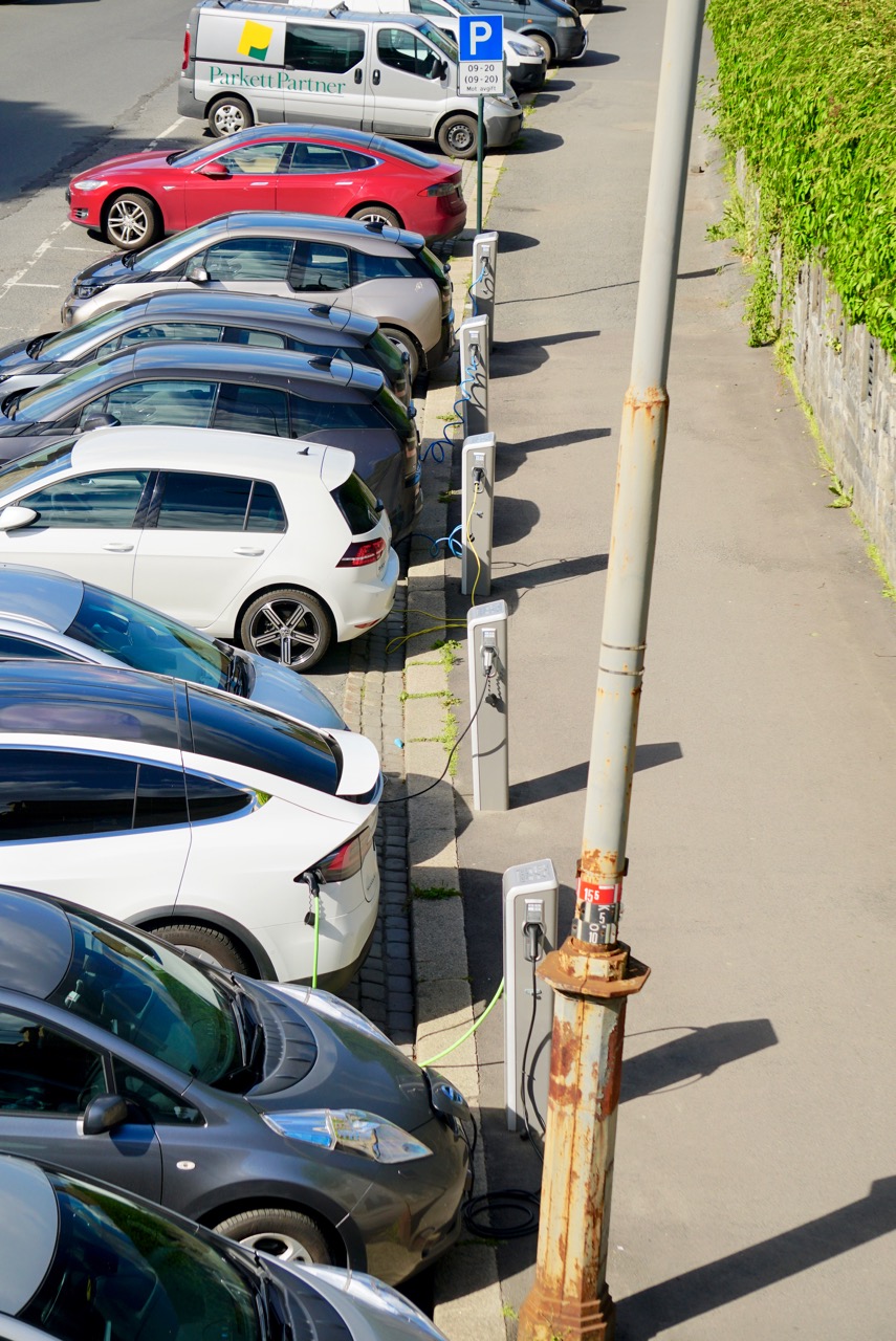 Electric cars charging on a city street. Oslo has a large number of electric vehicles, especially many Teslas.