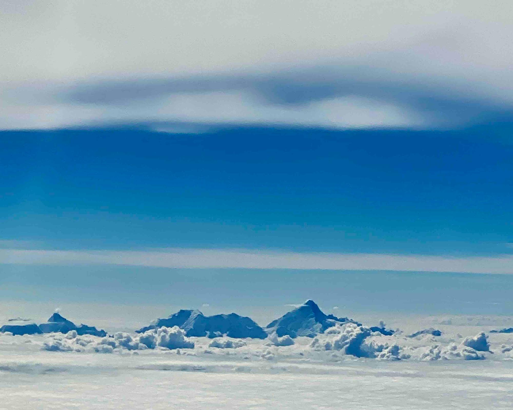 View from the Plane of 20k+ mountain peaks jutting above the ocean of clouds 